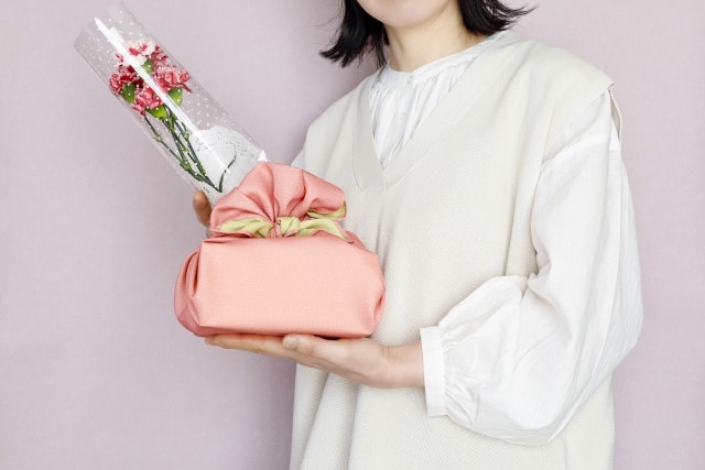 A woman with a present and carnations