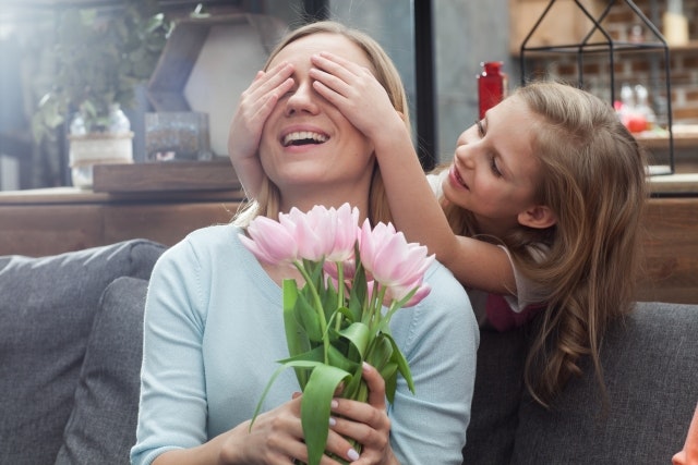A child surprising her mother with a gift